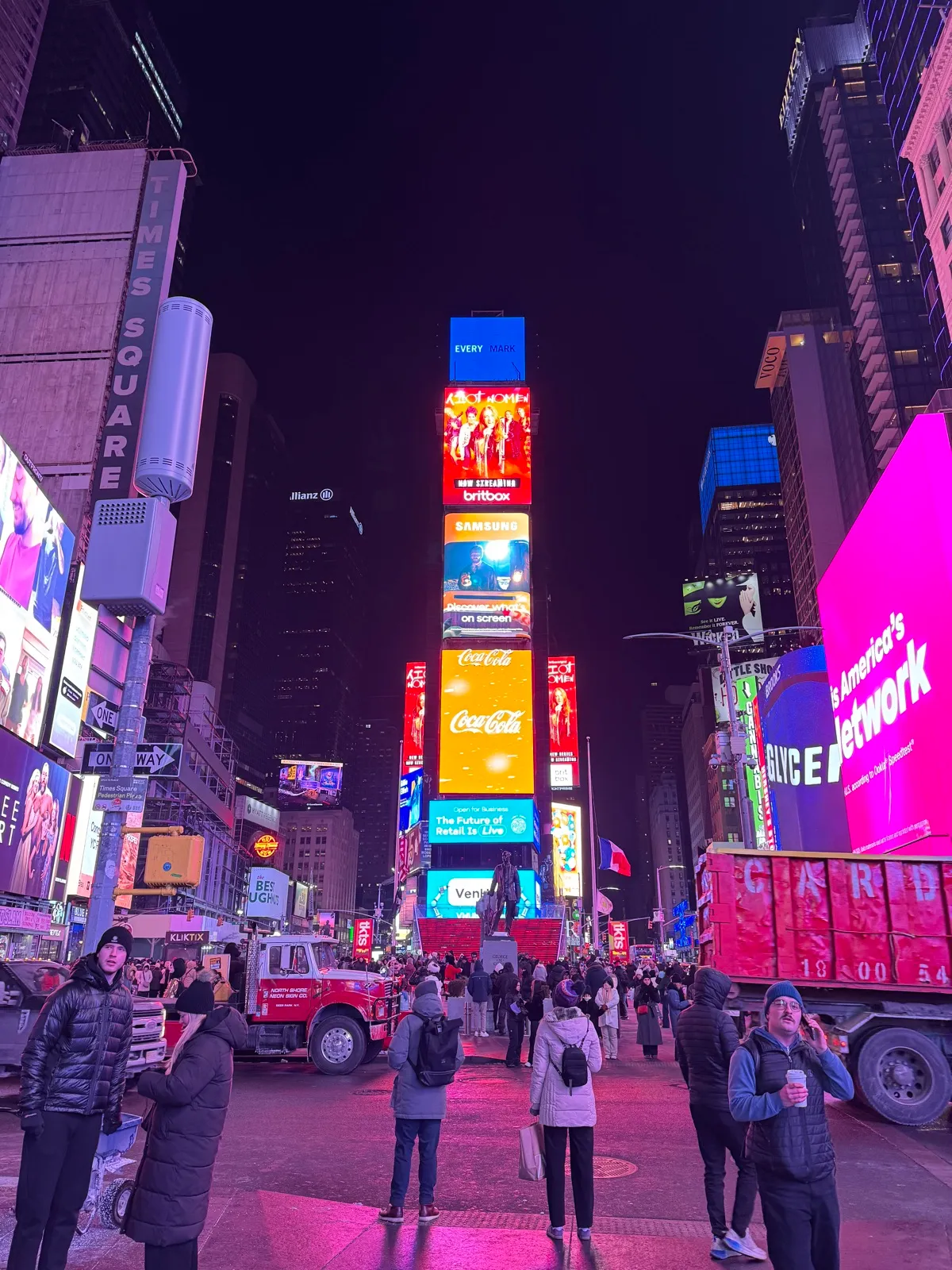 Bright billboards and crowds filling Times Square after dark
